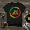 Black t-shirt with "1 LOVE VIBES" text inside a circular Rasta-colored design