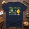 100 days and counting t-shirt with a chart, piggy bank, calendar showing 100, and trophy graphic