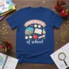 100 DAYS of school t-shirt with books, apple, and diploma graphics. Features colorful text and playful illustrations celebrating the 100th