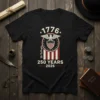 Black t-shirt with "1776 We The People 250 Years 2026" design featuring an eagle, shield, and American flag elements