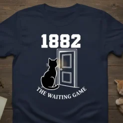 Navy t-shirt with white text "1882 The Waiting Game" and a graphic of a black cat sitting by a door