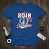 Blue t-shirt featuring "2018 77 Champions" text with a hockey trophy graphic and laurel wreath