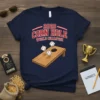 2020 Corn Hole World Champion text with graphic of cornhole board and baseballs on a navy t-shirt