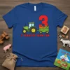 Blue t-shirt with "3 Years Of Farm Fun" text, a green tractor, and a wagon filled with pumpkins and corn