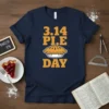 Navy blue t-shirt with "3.14 PI.E DAY" in orange text and a graphic of a pie