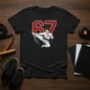 Black t-shirt featuring the number 67 in red and white with a cartoon karate fighter mid-kick