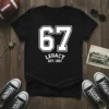 Black t-shirt with white "67 LEGACY EST. 1967" text in a collegiate style, perfect for a 1967 birth year legacy