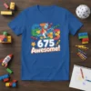 Blue t-shirt design featuring the text "675 Awesome!" with building blocks, a rocket ship, and crayons