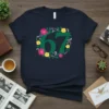 Green number 67 surrounded by a floral wreath with pink and yellow flowers and green leaves on a navy t-shirt