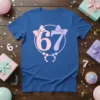 Royal blue t-shirt with "67" in pink and purple, framed by bows and pearls, celebrating a 67th birthday