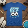 Graphic t-shirt design featuring the number 67 styled like a blue donut with sprinkles, and two soccer balls below, on