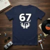 T-shirt design featuring the number 67 in large white font with black outline, held by cartoon hands