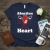 Navy blue t-shirt with bold white text "Abortion Stops A Beating Heart" and a graphic of a heart with a