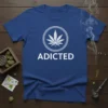 Blue t-shirt with white "ADDICTED" text and a white cannabis leaf inside a circle graphic
