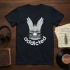 White text "addicted" curved below a white graphic of a pipe organ keyboard and pipes on a black t-shirt