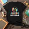 Adopt Don't Shop t-shirt with dog and cat silhouette in tie-dye circle, and colorful text