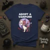 Adopt A Vampurrr Halloween t-shirt featuring a cute, stitched vampire cat with bat wings and the text "ADOPT A VAMPURR"