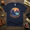 Adventure Awaits cat t-shirt design with a blue cat looking at a city skyline and a bridge