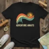 Black t-shirt with "ADVENTURE AWAITS" text and a vintage graphic of a person flying a kite at sunset