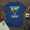 Adventure Awaits text on a navy t-shirt with a graphic of mountains and pine trees inside a triangle