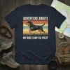 Graphic t-shirt with white text "ADVENTURE AWAITS MY DOG IS MY CO-PILOT" and a running dog illustration on a sunset