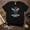 Adventure Awaits text with anchor, wings, and ship wheel graphic on a black t-shirt