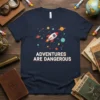 Navy blue t-shirt with white text "ADVENTURES ARE DANGEROUS" and a colorful rocket ship illustration with planets and stars
