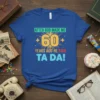 After God Made Me 60 Years Ago He Said Ta Da! text design on a royal blue t-shirt, featuring the