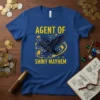 Agent Of Shiny Mayhem t-shirt design with a black raven flying amidst gold coins and swirling yellow accents