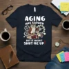 T-shirt with the text "AGING HAS SLOWED BUT IT HASN'T SHUT ME UP!" featuring a cartoon owl on books with