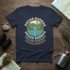 Navy blue t-shirt with colorful "Aguas Buenas" text encircling a stylized waterfall and mountain landscape graphic