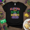 Alabama Real Home of Mardi Gras t-shirt design with colorful text, palm trees, and a cityscape graphic