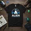 Black t-shirt with 'ALIEN NOT ALONE NEVER WERE' text and a UFO abduction graphic in a desert landscape