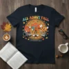 T-shirt featuring "All About Fall (Prevention)" text with cartoon fall characters in a circle, including a leaf, pumpkin, and acorn