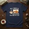 Navy t-shirt featuring the quote "ALL I NEED IS TEA AND MY CAT" with a sleeping cat on a laptop