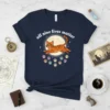 All nine lives matter text with jumping orange tabby cat graphic and colorful paw prints on a navy t-shirt
