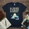 Navy t-shirt with the motivational quote "All You Need Is To Believe In Yourself" above a graphic of a person