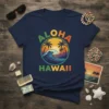 Aloha Hawaii text with a circular design of a tropical sunset, palm trees, and a breaking wave on a navy