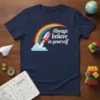 Always believe in yourself quote with a rocket and rainbow graphic on a navy blue t-shirt