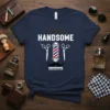 Navy blue t-shirt with "ALWAYS HANDSOME" text and barber pole, scissors, mustache, and comb graphic