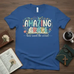 Christian t-shirt with "Amazing Grace how sweet the sound" quote in colorful, decorative lettering above an open book graphic