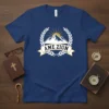 AME ZION text on a navy blue t-shirt with a mountain and sun graphic, surrounded by laurel leaves