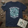 Navy t-shirt with "ANCIENT OCEAN TREASURES FOSSIL COLLECTION" text and a central vortex graphic of various fossils like ammonites and
