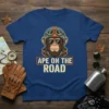 Ape On The Road text with a monkey wearing a motorcycle helmet and sunglasses on a blue t-shirt