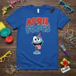 Blue t-shirt with bold red and blue "APRIL FOOL'S" text above a cartoon character with a party hat, sticking its