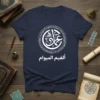 Navy blue t-shirt with white Arabic calligraphy design reading عُدِّيْهُمْ أَلْغِيْمُ الْمِيْوَام, featuring a circular ornamental pattern