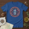 Blue t-shirt with circular Arabic calligraphy design that reads 'غمة' in white, surrounded by red and green floral patterns