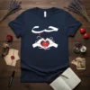 Arabic word 'حب' (Hub) for love with a heart-shaped hand gesture cradling a red rose graphic on a navy t-shirt