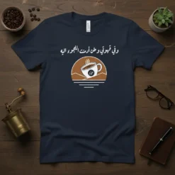 Arabic quote "وفى قهوتي وطن أرست اللجوء اليه" with a steaming coffee cup graphic on a navy t-shirt