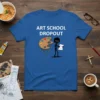 Blue t-shirt with white text "ART SCHOOL DROPOUT" and a graphic of a sad stick figure holding a bill next